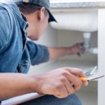 home inspector looking under the kitchen sink